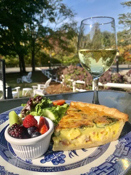 Quiche with fresh fruit and a glass of white wine on the patio