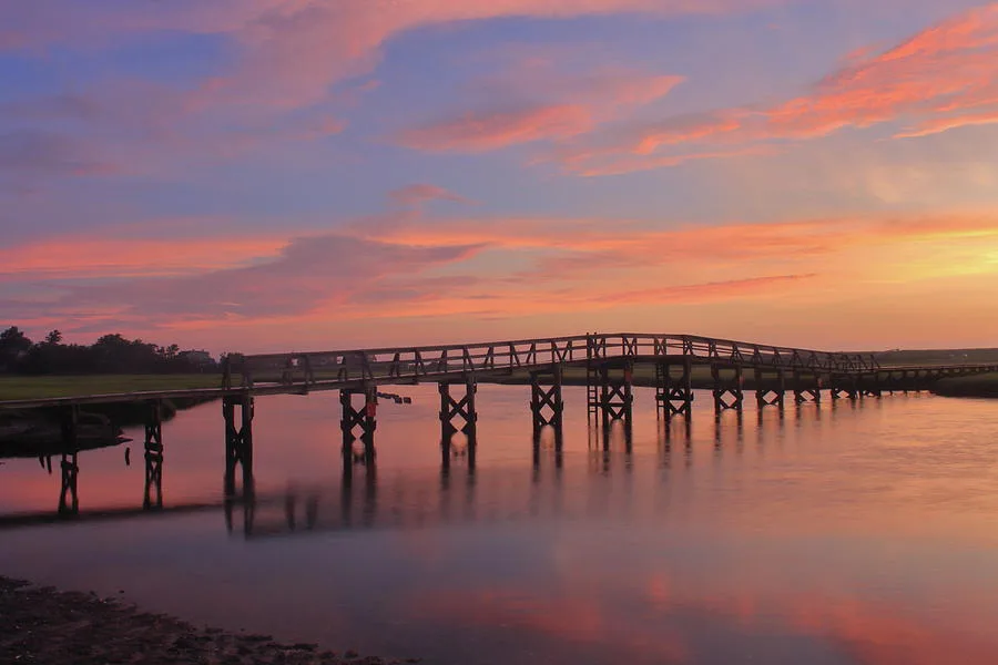 A pink and orange sunset over the Sandwich boardwalk and marsh