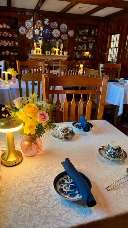 A wood-paneled dining room with a table set in blue and white china