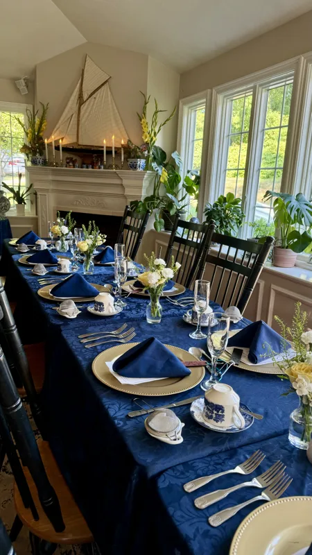 Long tables with navy napkins in the bright Shawme Room with garden windows
